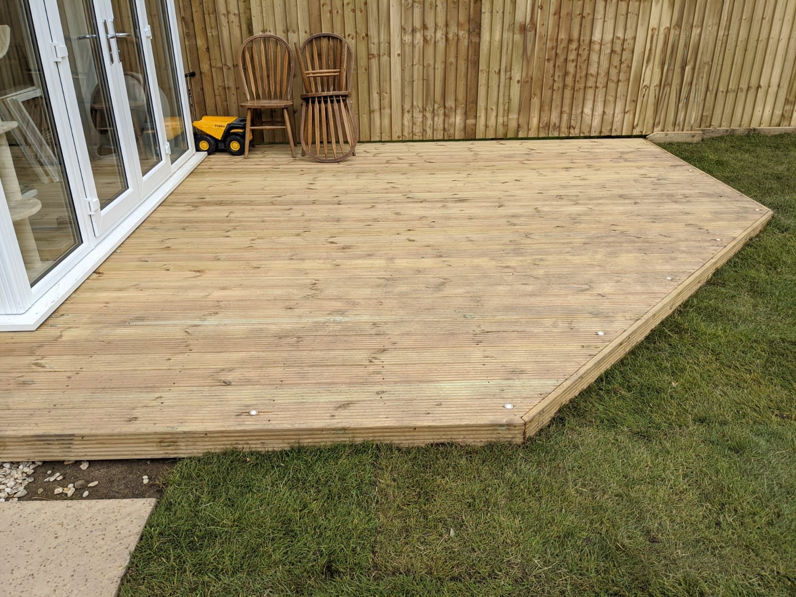 New timber deck with recessed lights meeting white French doors and a lawn